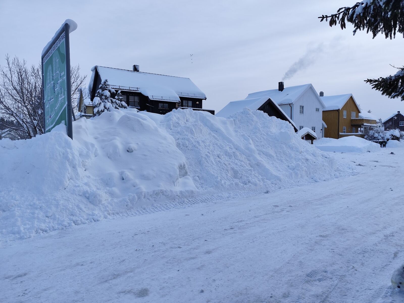 Brøytet vei i boligfelt med høye snøkanter langs veikanten